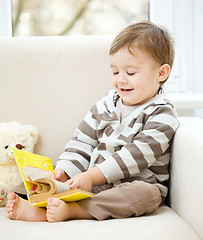 Image showing Little boy is reading book