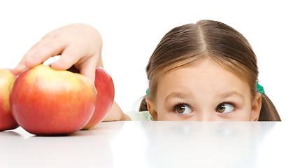 Image showing Little girl is reaching apple