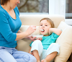 Image showing Cute little boy is fed using spoon