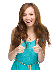 Image showing Woman is showing thumb up gesture