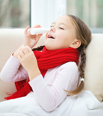 Image showing Little girl spraying her nose