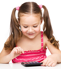 Image showing Little girl is using calculator