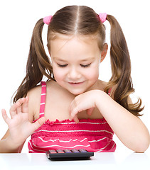 Image showing Little girl is using calculator