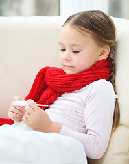 Image showing Ill little girl is reading thermometer