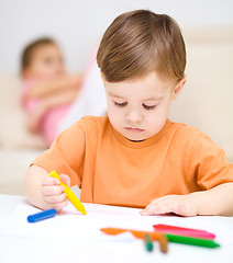 Image showing Little boy is drawing on white paper