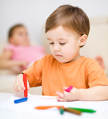 Image showing Little boy is drawing on white paper