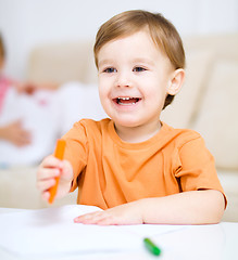 Image showing Little boy is drawing on white paper