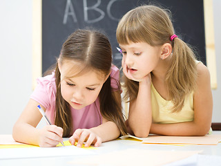 Image showing Little girls are writing using a pen