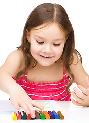 Image showing Little girl is drawing using colorful crayons