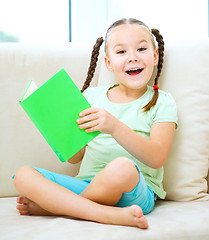 Image showing Little girl reads a book