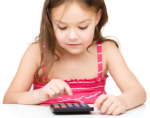 Image showing Little girl is using calculator