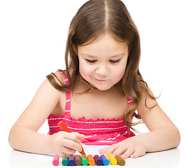 Image showing Little girl is drawing using colorful crayons