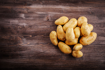 Image showing Fresh organic potatoes on a wooden table