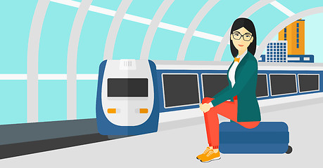 Image showing Woman sitting on railway platform.