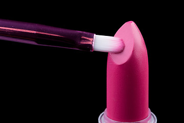 Image showing Tube of lipstick with a brush make-up on black 