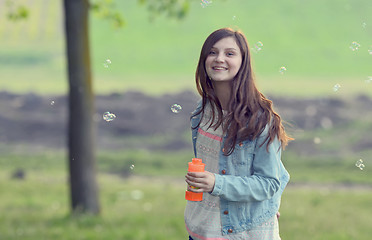 Image showing Young girl play with soap-bubbles