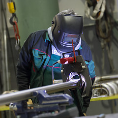 Image showing Industrial worker setting orbital welding machine.