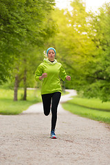 Image showing Sporty young female runner in city park.. 