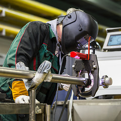 Image showing Industrial worker setting orbital welding machine.