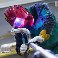 Image showing Industrial worker welding in metal factory.