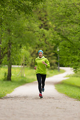 Image showing Sporty young female runner in city park.. 