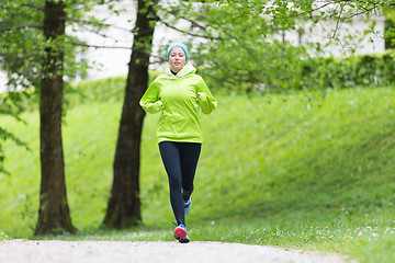 Image showing Sporty young female runner in city park.. 