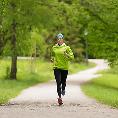 Image showing Sporty young female runner in city park.. 