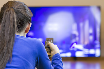 Image showing Tennager girl laying down and watching at tv 