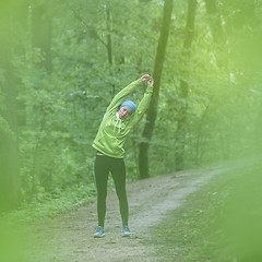 Image showing Sporty woman  working out in forest. 