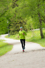 Image showing Sporty young female runner in city park.. 