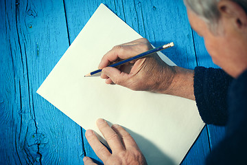 Image showing Senior man with blank white paper sheet and pencil