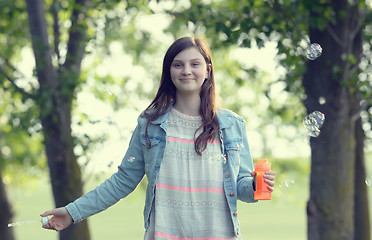 Image showing Girl play with soap-bubbles in forest