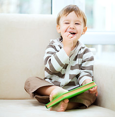 Image showing Little boy is reading book