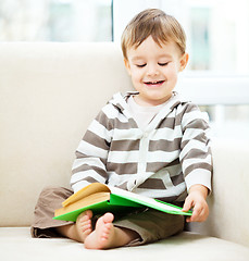 Image showing Little boy is reading book