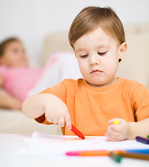 Image showing Little boy is drawing on white paper