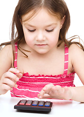 Image showing Little girl is using calculator