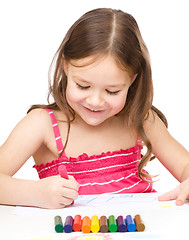 Image showing Little girl is drawing using colorful crayons