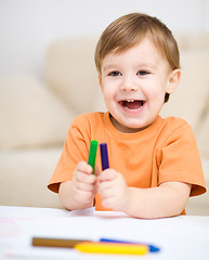Image showing Little boy is drawing on white paper
