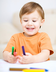 Image showing Little boy is drawing on white paper