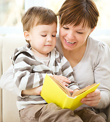 Image showing Mother is reading book for her son