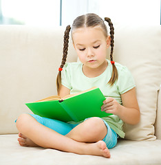 Image showing Little girl reads a book