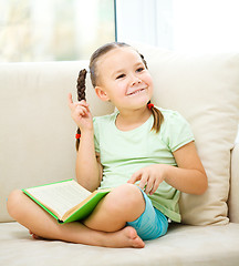 Image showing Little girl reads a book