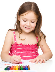 Image showing Little girl is drawing using colorful crayons