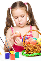 Image showing Little girl is painting eggs preparing for Easter