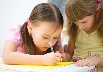 Image showing Little girls are writing using a pen