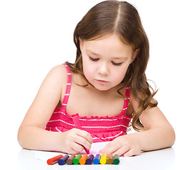 Image showing Little girl is drawing using a crayons