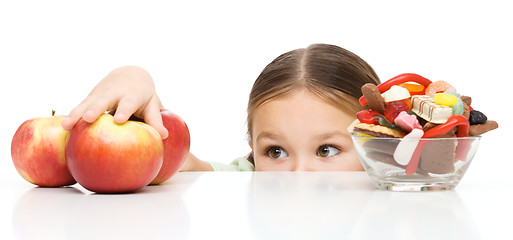 Image showing Little girl is reaching apple