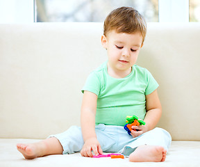 Image showing Boy is playing while sitting on couch