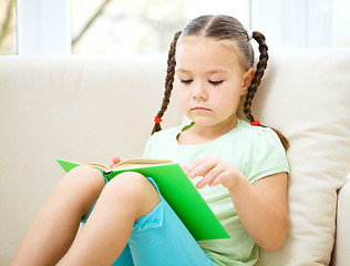 Image showing Little girl reads a book