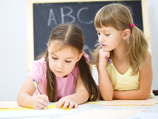 Image showing Little girls are writing using a pen